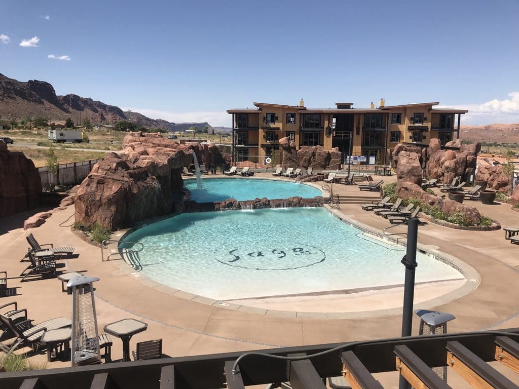 Sage Creek at Moab pool with complex in the background on a sunny day
