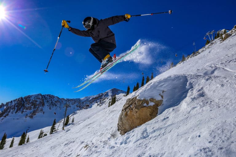 a skier jumping a rock at a Utah ski resort, popular tourist attractions in salt lake city, utah