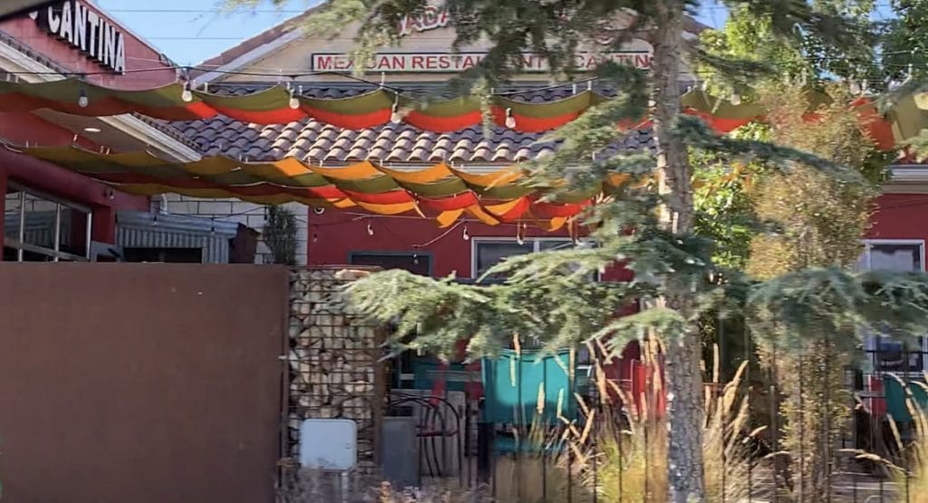 to show an exterior view of donkey tails cantina outdoor courtyard from the sidewalk