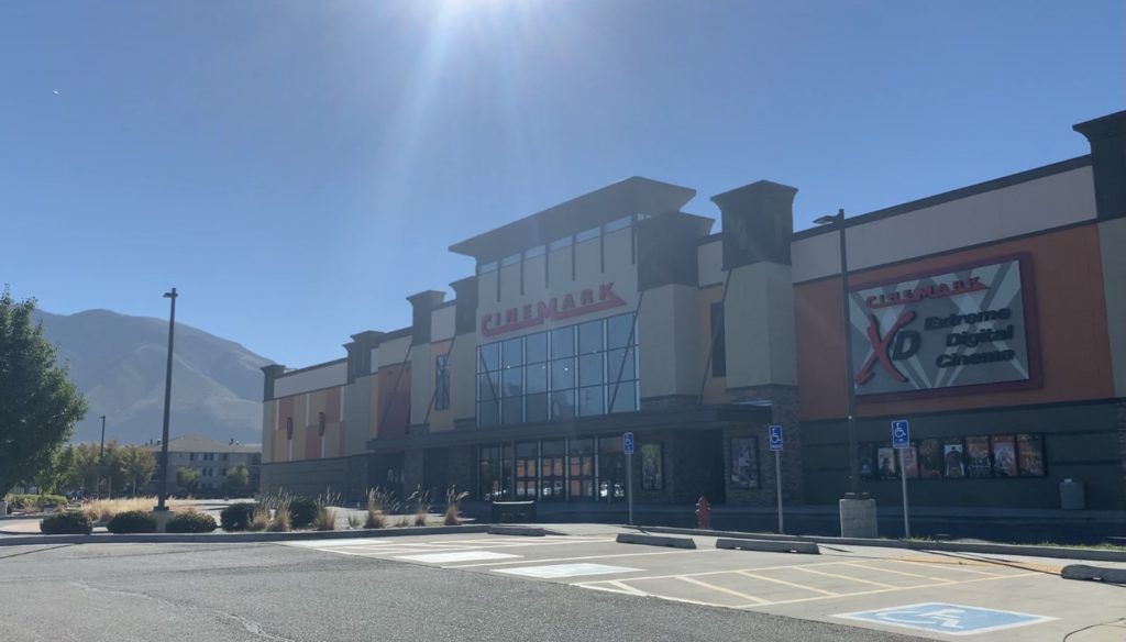 view of the front entrance to the cinemark movie theatre in draper utah with the wasatch mountains in the background